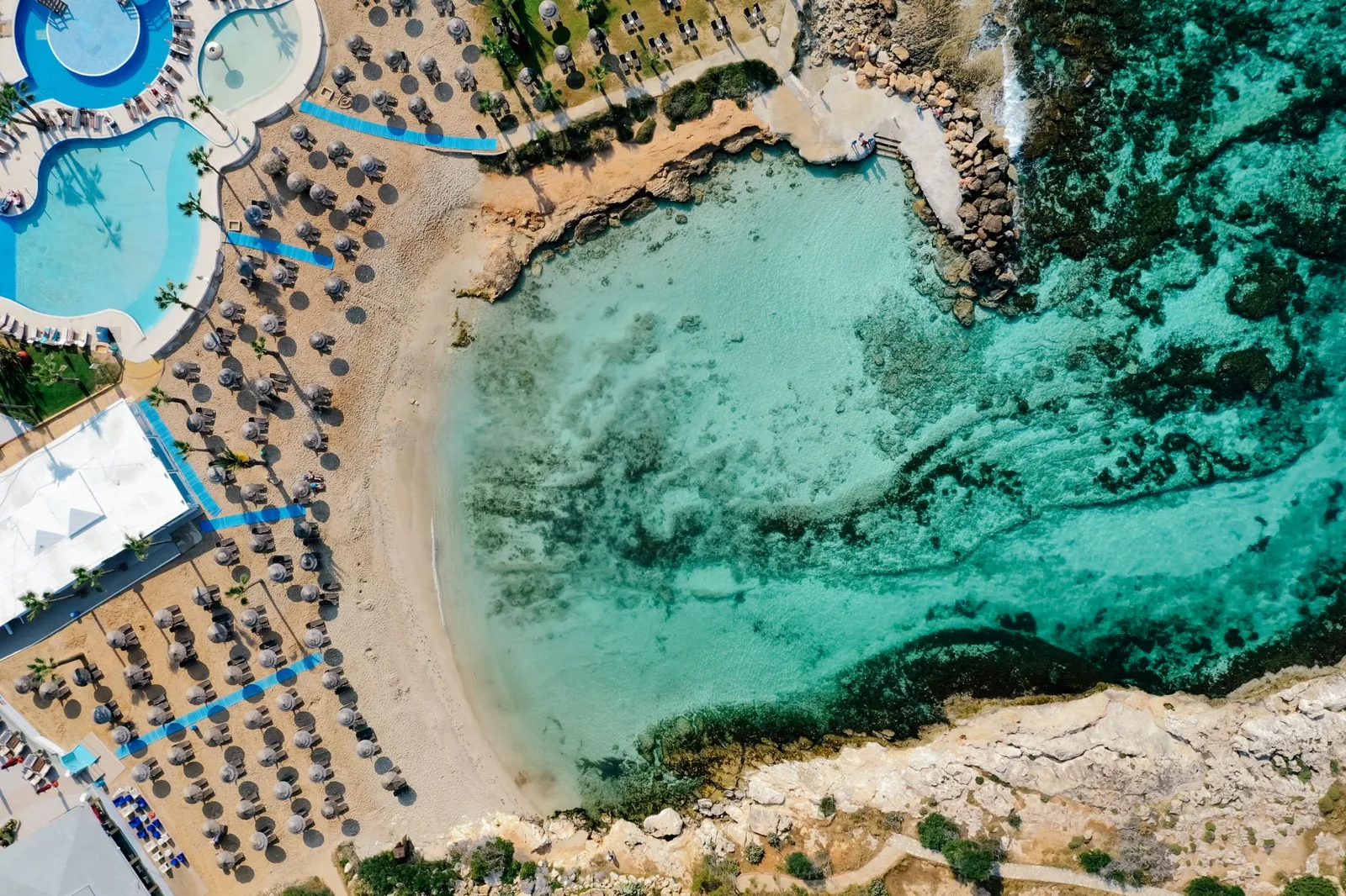 Couple reviewing all inclusive holiday resort prices on a tablet at a beach resort